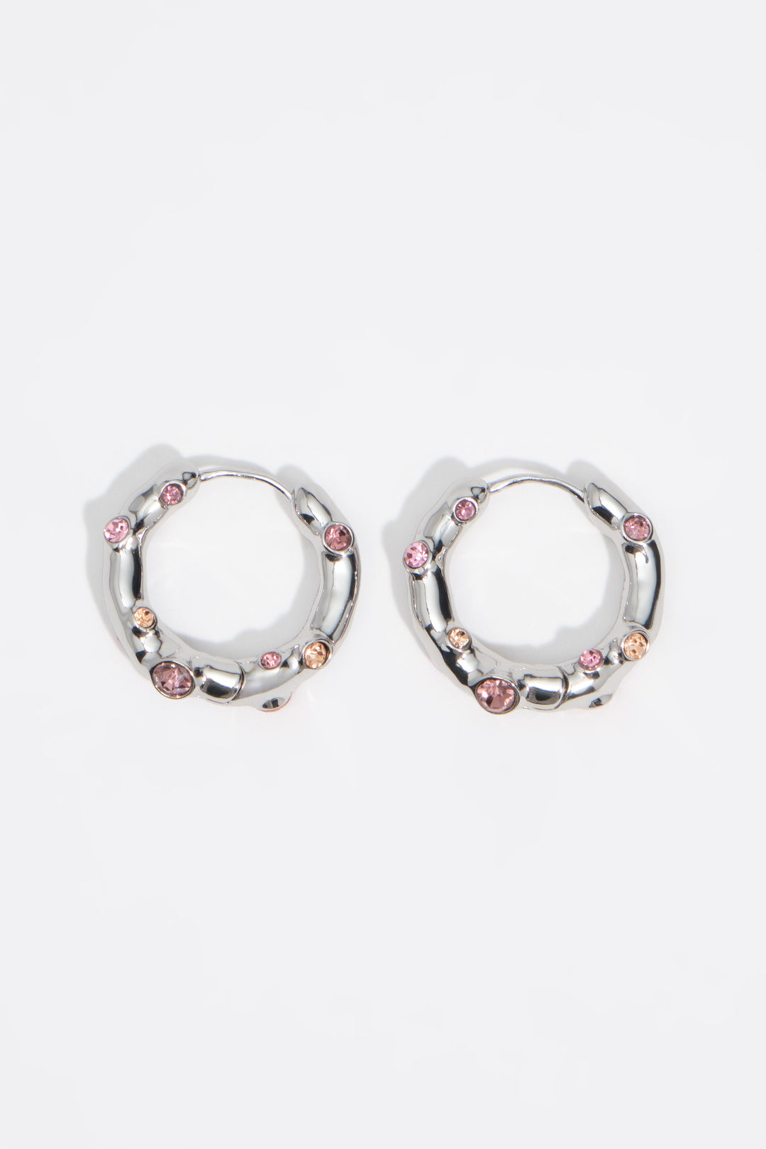 Silver textured metal hoop earrings with pink crystals
