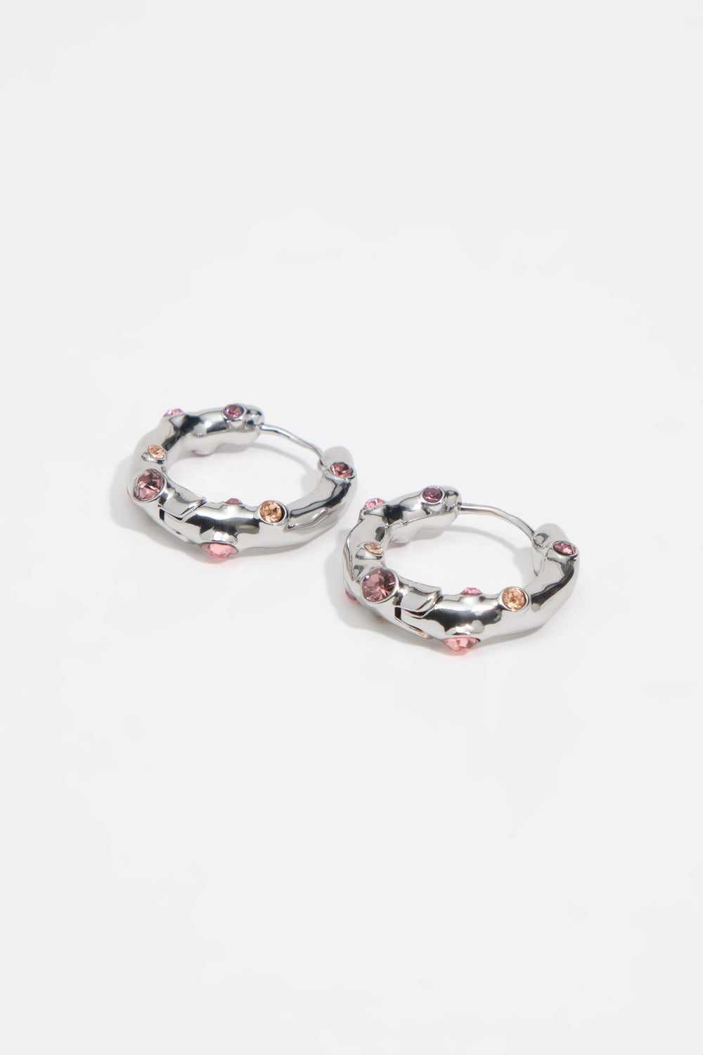 Silver textured metal hoop earrings with pink crystals