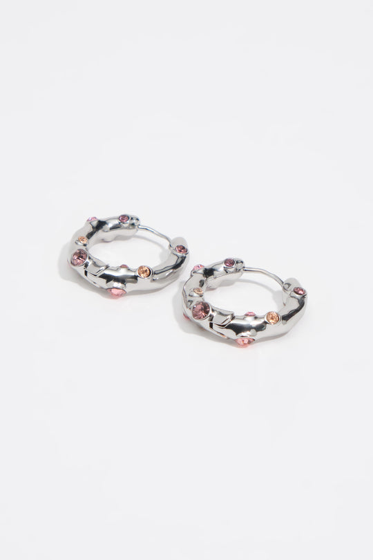 Silver textured metal hoop earrings with pink crystals