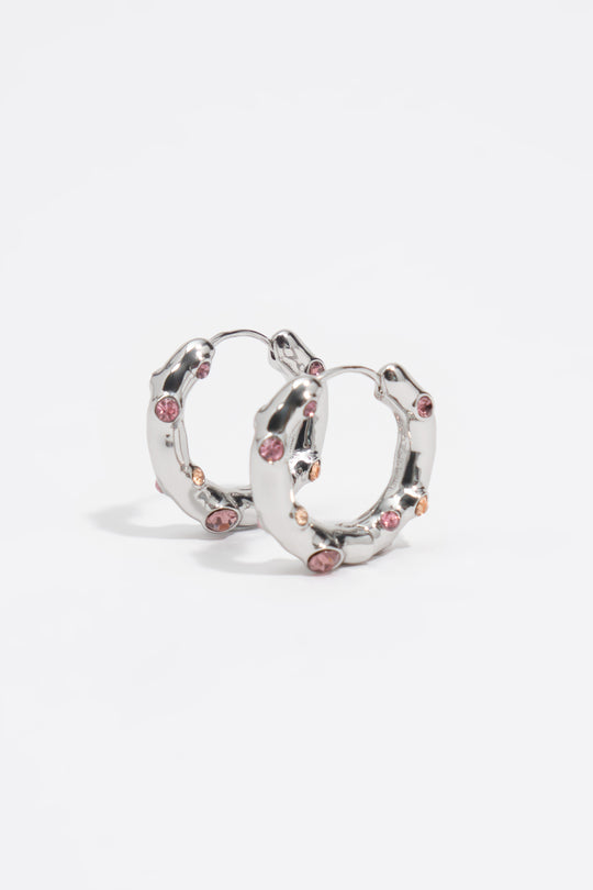 Silver textured metal hoop earrings with pink crystals