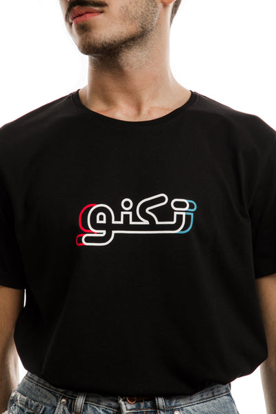 young adult male wearing black t-shirt with techno written in arabic تكنو and in blue, red and white in the center of the t-shirt