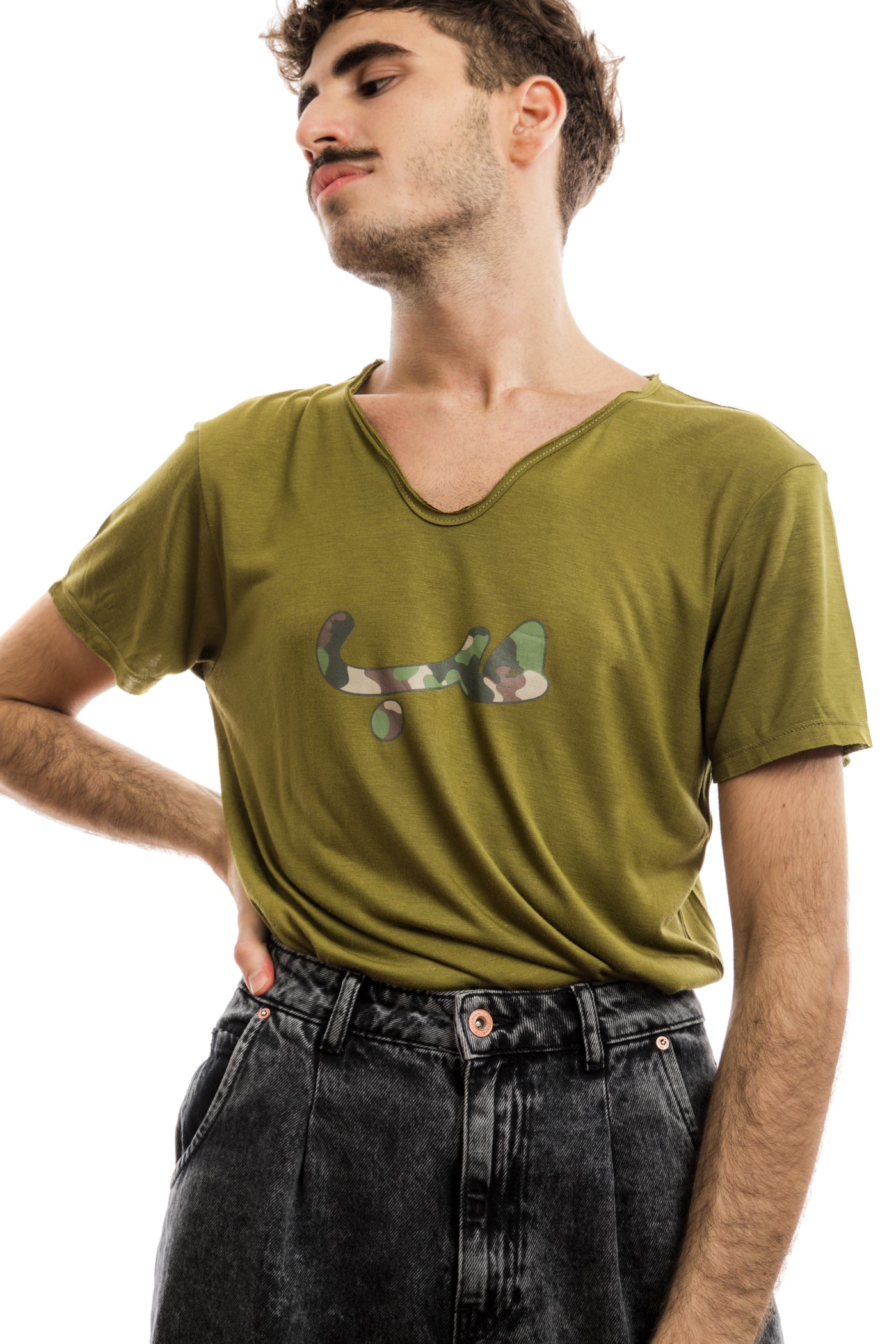 young adult male wearing olive green t-shirt with hobb written in arabic حب and in army pattern in the center of the t-shirt along with black jeans